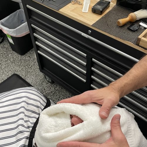 hot towel in mans face for shaving